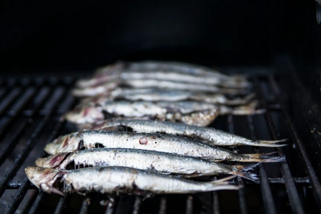 Espetos de sardinas a la malagueña: la receta de playa que en agosto solo funciona con leña de olivo